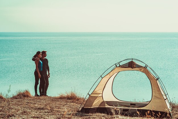 L'homme et la femme se reposent dans le camping près de la mer