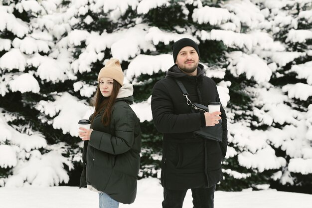 L'homme et la femme se reposent dans le parc d'hiver