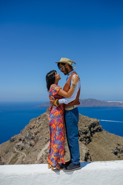 Un homme et une femme se serrent contre le rocher de Skaros sur l'île de Santorin. Le village d'Imerovigli est un gitan ethnique. Elle est israélienne.