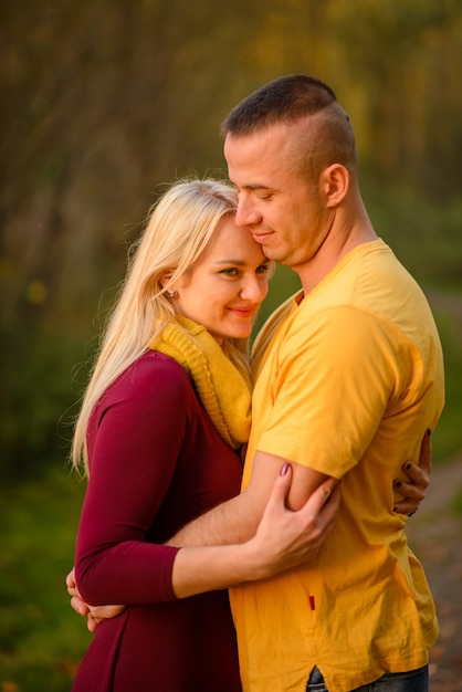 L'homme et la femme se serrent dans le parc en automne.