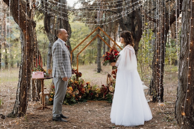 L'homme Et La Femme Se Sont Fiancés Dans La Forêt D'automne Lors D'une Cérémonie De Décoration De Mariage