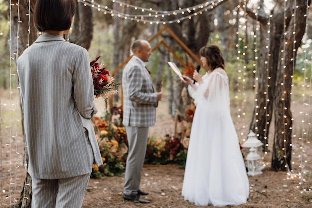 L'homme et la femme se sont fiancés dans la forêt d'automne lors d'une cérémonie de décoration de mariage