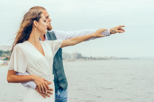 homme et femme se tenant la main au bord de la mer