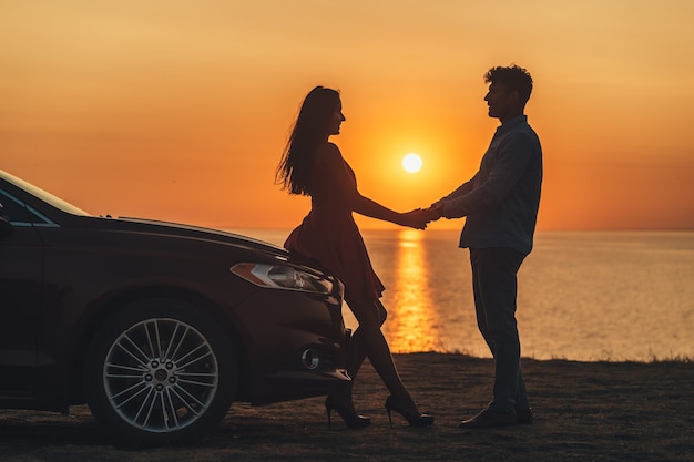 L'homme et la femme se tenant la main sur le beau fond de bord de mer