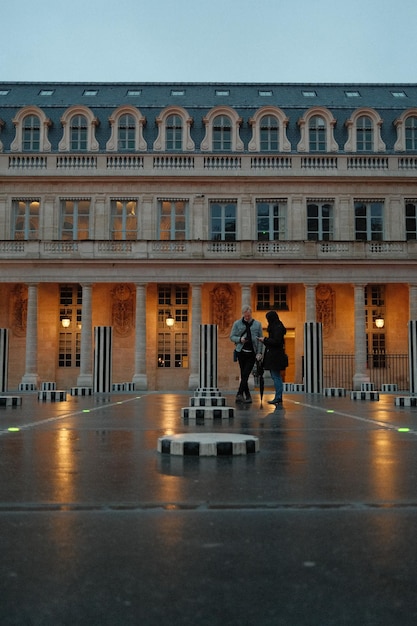 Un homme et une femme se tiennent dans la cour du PalaisRoyal de Paris, France.