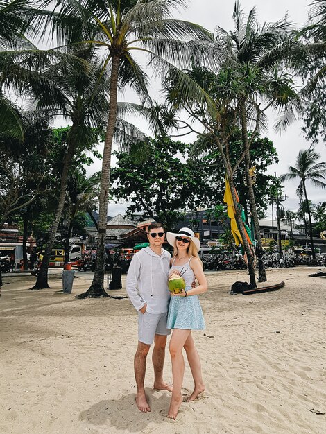 Homme et femme séduisante avec noix de coco sur la plage de Patong, Phuket, Thailand