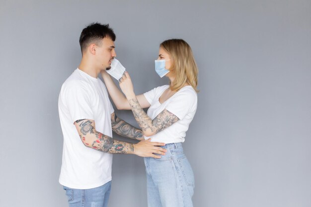 Un homme et une femme sérieux, les mains croisées, debout dos à dos après la querelle portent un masque médical