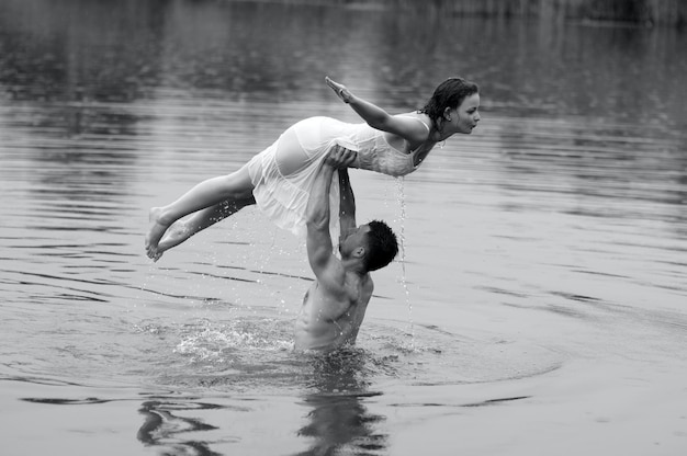 Un homme et une femme sont dans l'eau, ils soutiennent la femme.