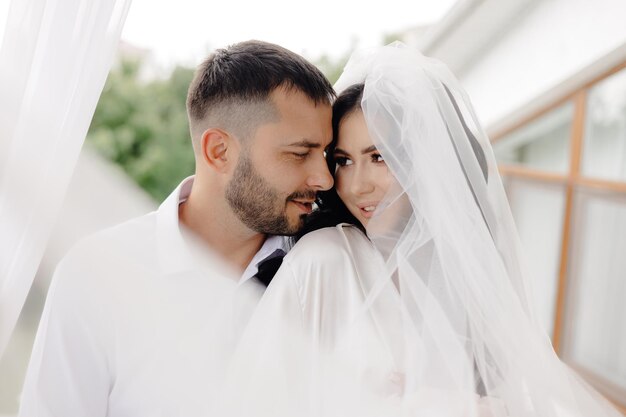 Photo un homme et une femme sourient et la femme porte une robe blanche