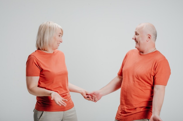 homme et femme en t-shirts orange sur fond blanc