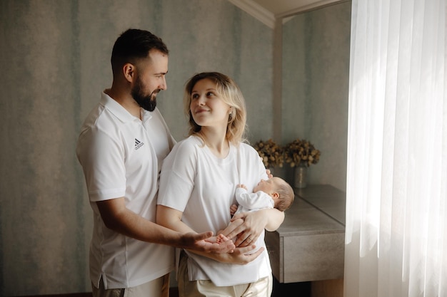 un homme et une femme tenant un bébé et souriant