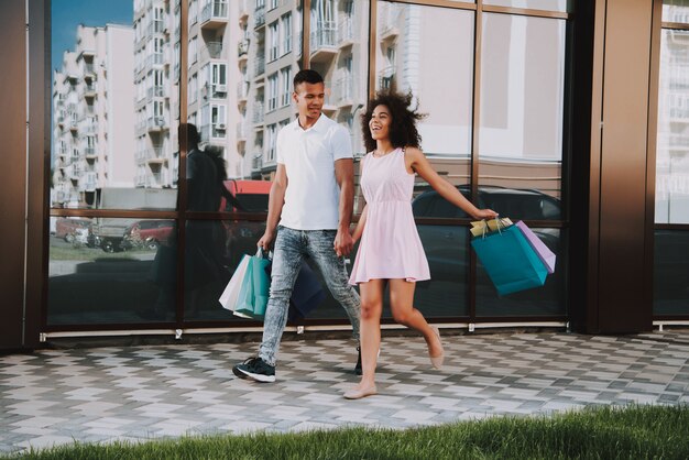 Homme et femme tient des sacs de shopping Sunshine Summer Day