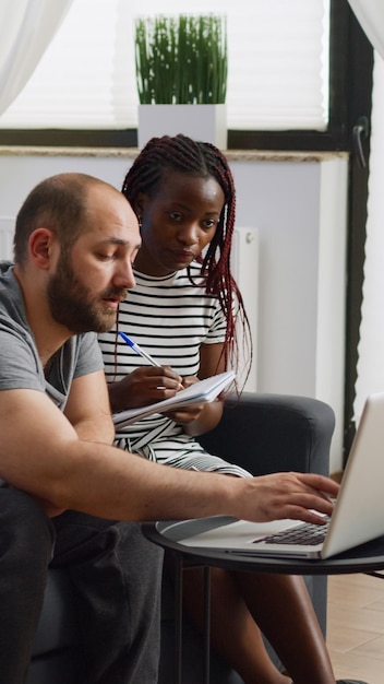 Photo un homme et une femme travaillent sur un ordinateur portable.