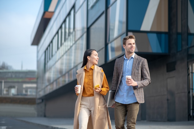 Homme et femme traversant la rue au passage pour piétons en parlant