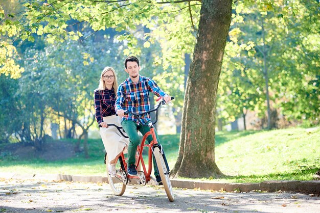 Homme et femme à vélo ensemble double vélo tandem