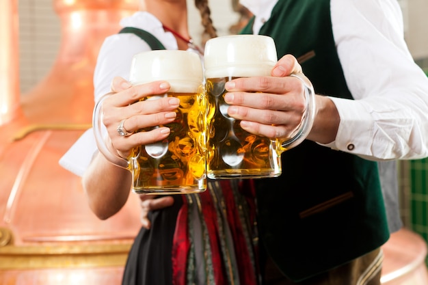 Homme et femme avec verre à bière dans une brasserie