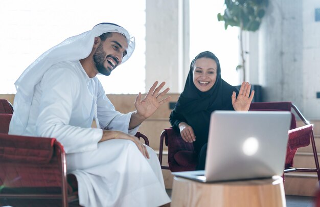 Homme et femme avec des vêtements traditionnels travaillant dans un bureau d'affaires de Dubaï