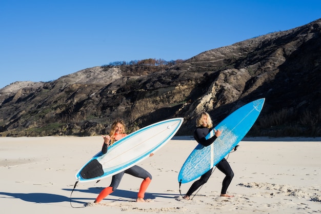 homme et femme vont à l&#39;océan avec des planches de surf. homme et fille vont surfer