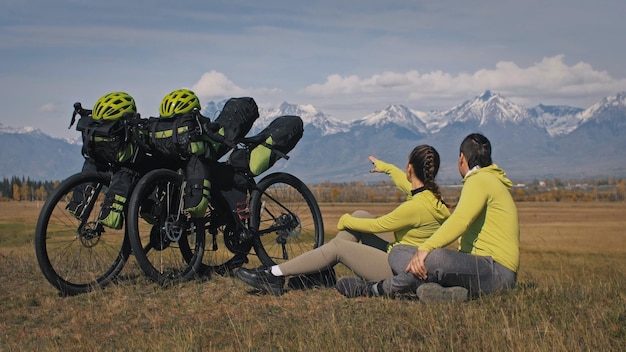 L'homme et la femme voyagent sur un terrain mixte cyclotourisme avec bikepacking Les deux personnes voyagent avec des sacs à vélo Montagne enneigée