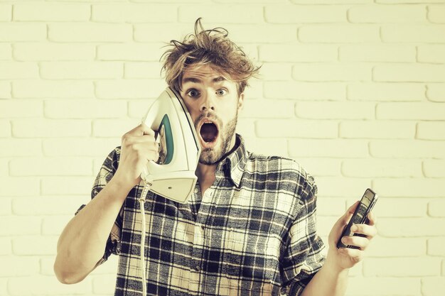 Homme avec fer et téléphone