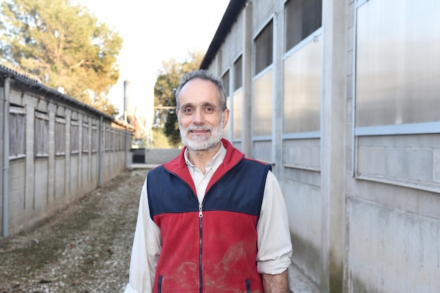 Homme de ferme devant une ferme d&#39;animaux