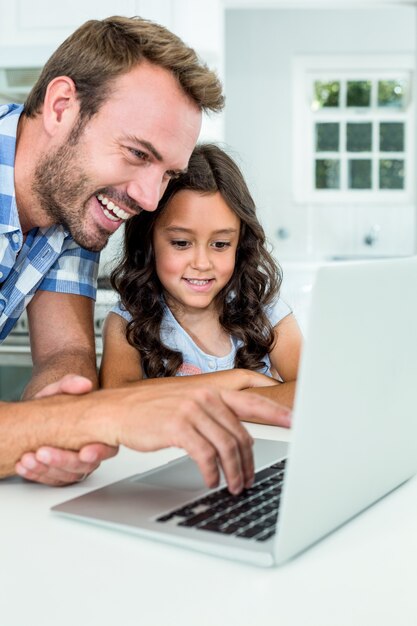 Homme avec fille à l'aide d'un ordinateur portable à la maison