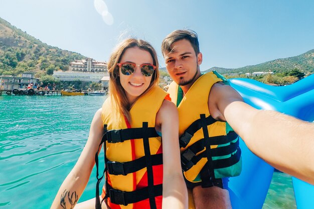 Un Homme Et Une Fille Heureux Prennent Un Selfie à Cheval Sur La Mer Sur Un Bateau Banane