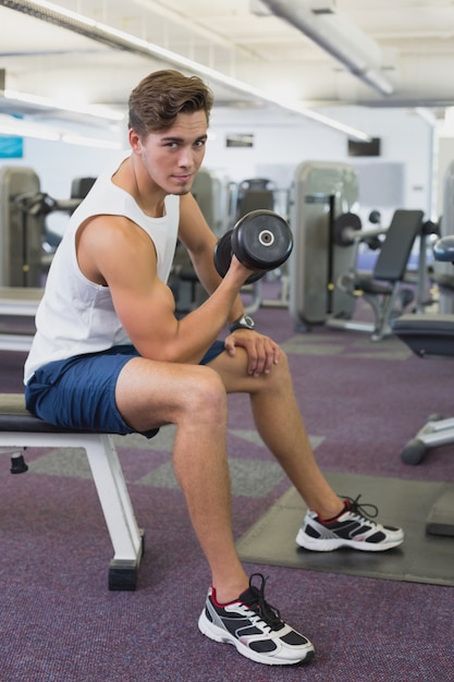 Homme fit soulever des haltères assis sur le banc