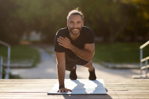 Photo un homme de fitness fait une démonstration d'exercice de planche sur une main dans un parc