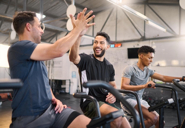 Homme de fitness et high five à la salle de gym pour l'entraînement physique ou l'entraînement cardio ensemble à l'intérieur Des hommes heureux avec le sourire et les mains en fête pour le soutien au partenariat ou la motivation sportive dans le bien-être