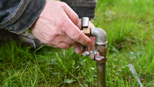 Homme Fixation Tuyau D'eau De Jardin.