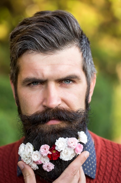 Homme avec des fleurs sur la barbe