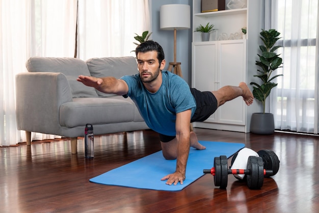 Homme flexible et de dextérité en vêtements de sport faisant une position de yoga gaieté inverse