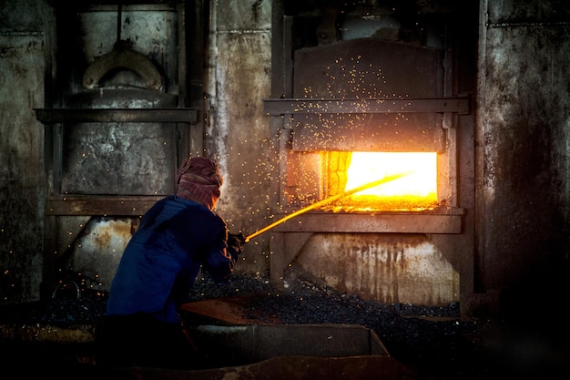 Un homme fondant du fer dans une usine