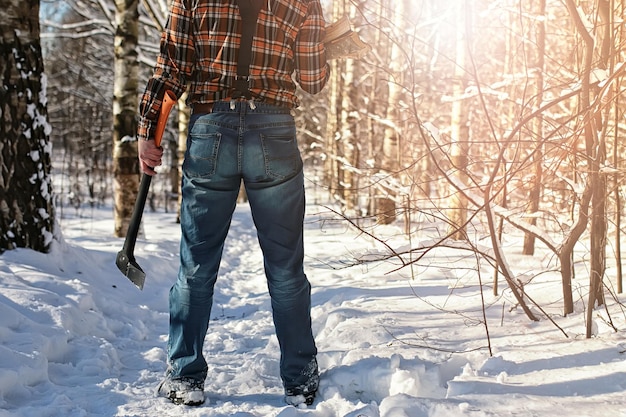 Homme de forêt d'hiver de bouleau avec la hache