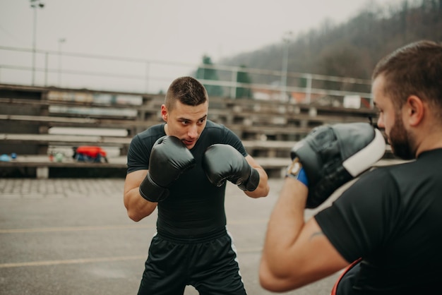 Homme formation kick box avec son entraîneur professionnel