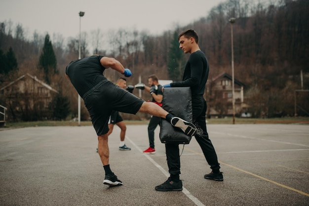 Homme formation kick box avec son entraîneur professionnel