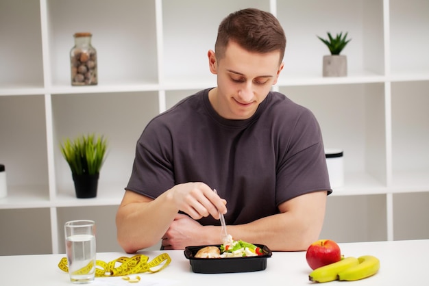 Homme en forme et en bonne santé tenant un bol de repas frais avec de la viande.