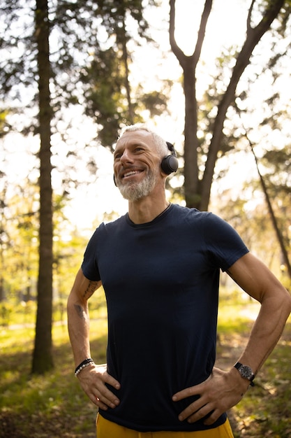 Homme en forme heureux écoutant de la musique en bois