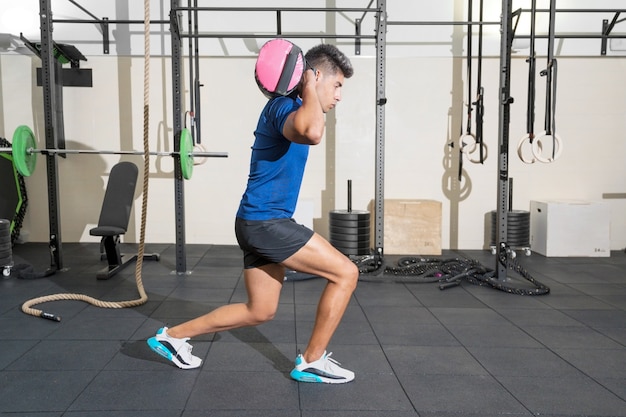 Homme de forme physique faisant la formation fonctionnelle au gymnase