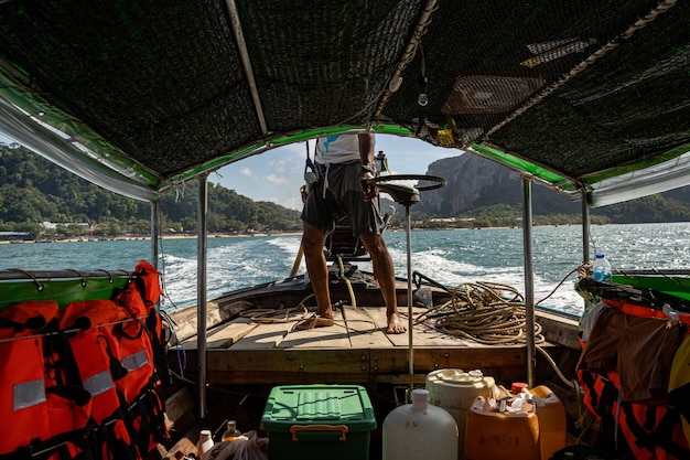 Homme fort conduisant un bateau, va visiter la nouvelle île