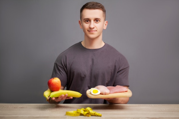 Un homme fort consomme un repas riche en protéines de viande et de fruits