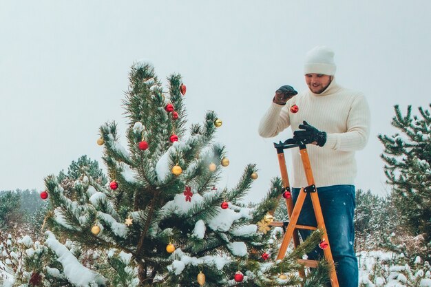 Homme fort décoration arbre de noël à l'extérieur de l'espace de copie