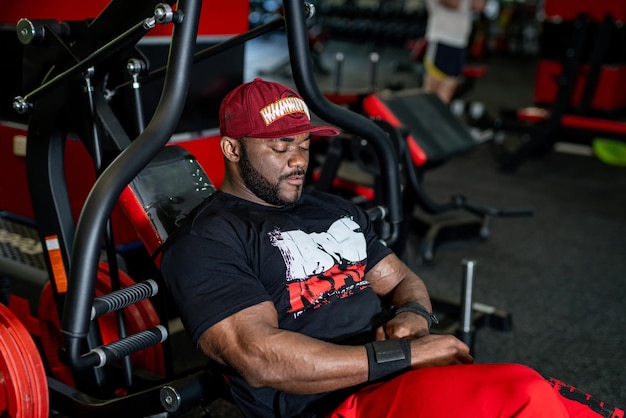 Homme fort posant devant la caméra. Bodybuilder musclé dans la salle de gym.