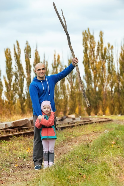 Homme fort en promenade avec sa petite fille en automne