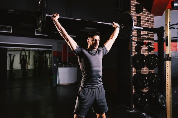 Photo un homme fort soulevant des poids et faisant des exercices de biceps au gymnase