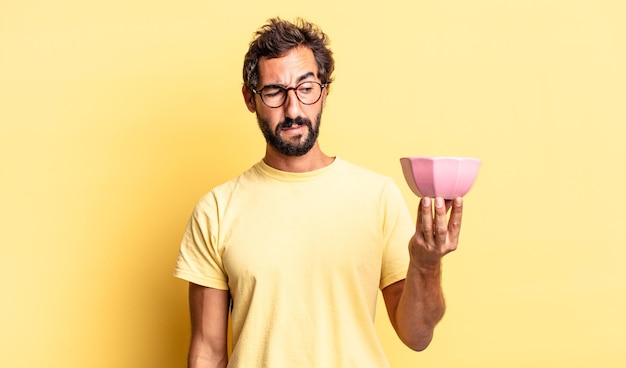 homme fou expressif se sentant triste, bouleversé ou en colère et regardant sur le côté et tenant un pot