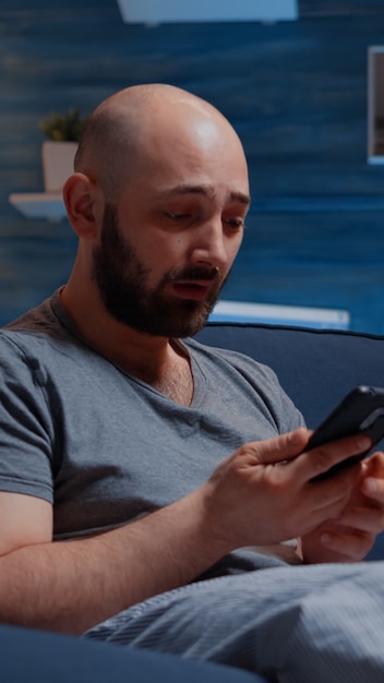 Homme frustré lisant des factures impayées de banque numérique pleurant ayant une notification, un avis d'expulsion
