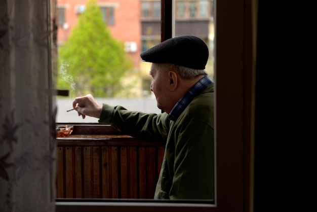 Homme fumant une cigarette sur le balcon