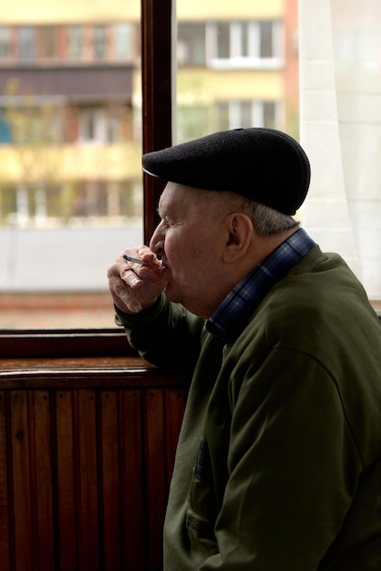 Homme fumant une cigarette sur le balcon